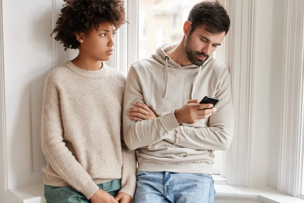 13 Relationship Issues, How To Avoid Them and Solutions 3 sad african woman looking at her man out of jealousy