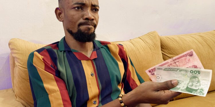 A man holds new naira notes in displeasure