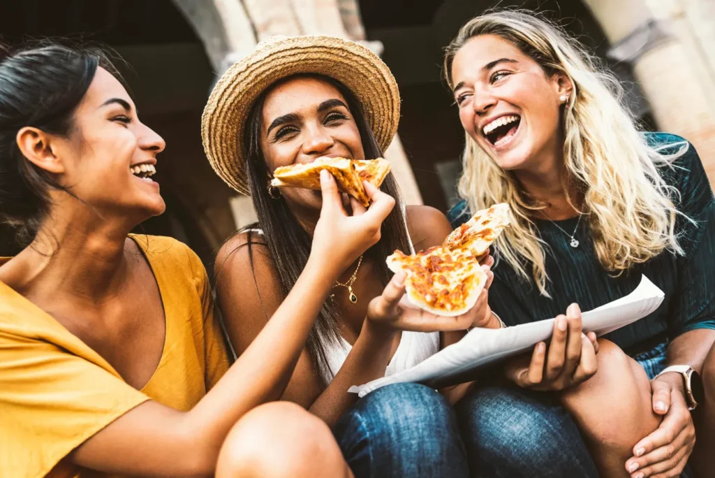 Money-Saving Hacks: 22 Easy Tips to Travel Europe on a Budget 4 A group of happy friends eating street food