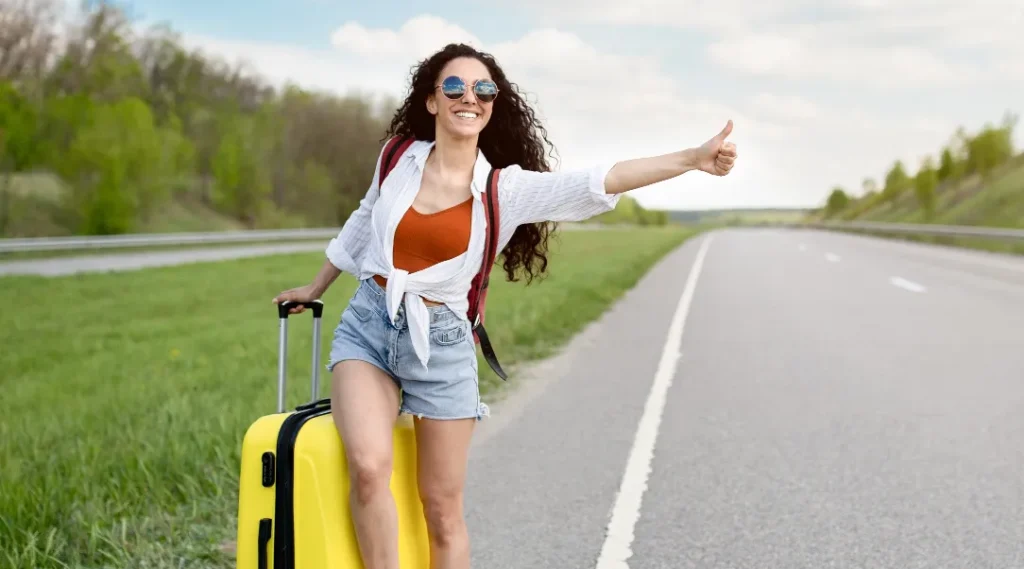 Money-Saving Hacks: 22 Easy Tips to Travel Europe on a Budget 2 A beautiful young lady Hitchhiking